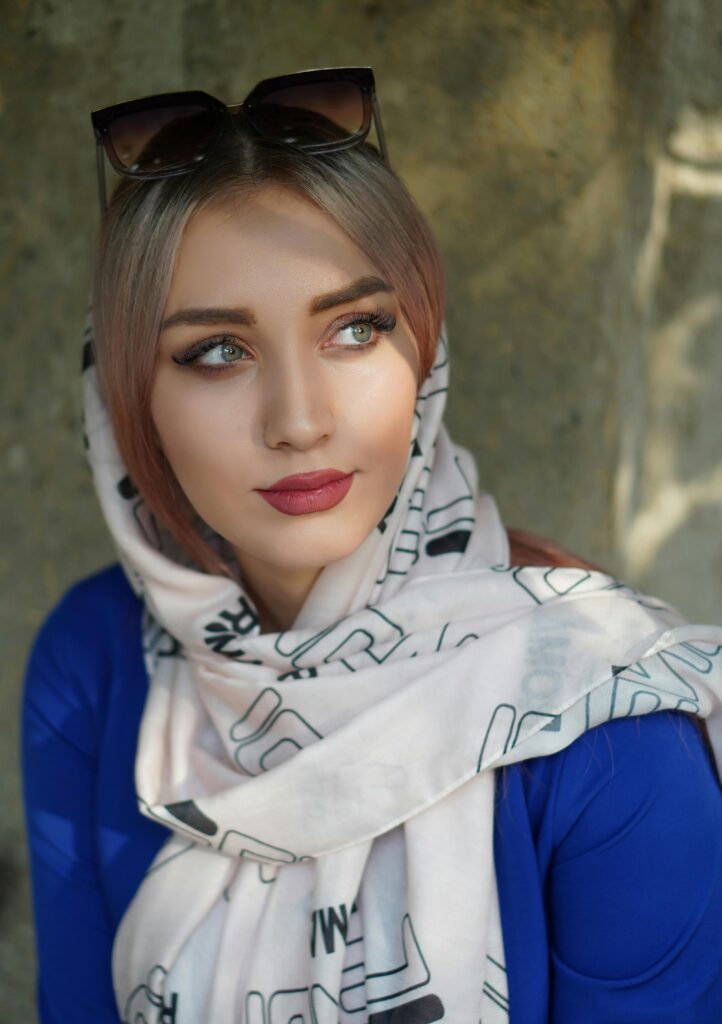 Portrait of a stylish woman in a headscarf and sunglasses looking away.
